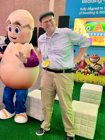 Ian McCullough with the Reading Eggs mascot at a conference booth
