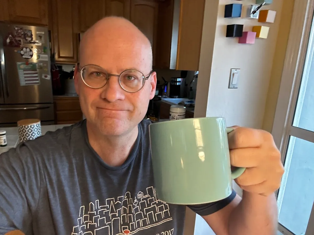 Ian McCullough holding a coffee mug in his kitchen