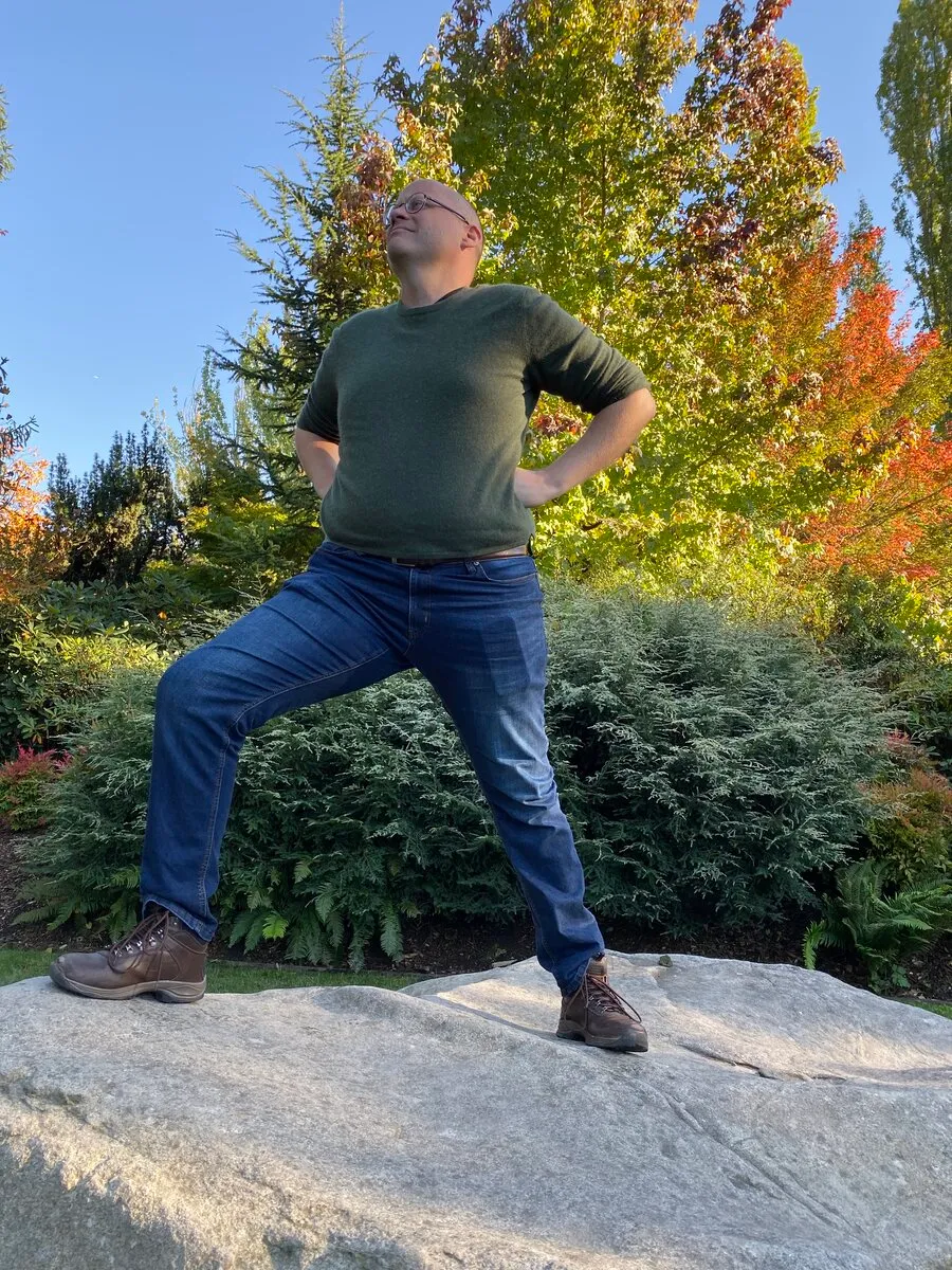 Ian McCullough striking a playful pose outdoors in a fall garden
