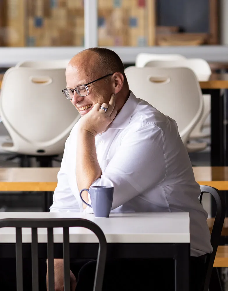 Ian McCullough smiling in conversation at a table
